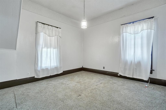 carpeted spare room featuring a textured ceiling