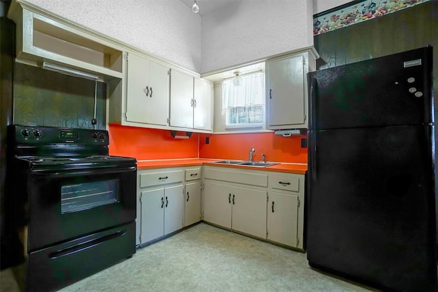 kitchen featuring black appliances, white cabinets, and sink