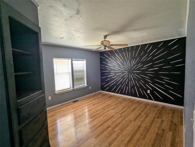 empty room featuring wood-type flooring, a textured ceiling, and ceiling fan