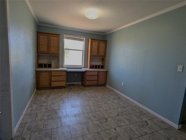 unfurnished office featuring built in desk and crown molding