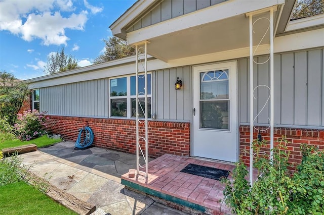 1033 Coe St, Altus, OK 73521 - property entrance with brick siding, board and batten siding, and a patio area