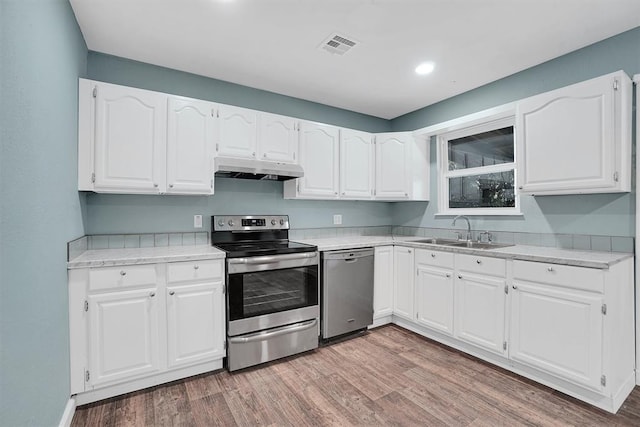 1033 Coe St, Altus, OK 73521 - kitchen with stainless steel appliances, a sink, under cabinet range hood, light wood-style flooring, and recessed lighting