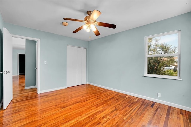 1033 Coe St, Altus, OK 73521 - unfurnished bedroom featuring light wood-type flooring, baseboards, a closet, and a ceiling fan