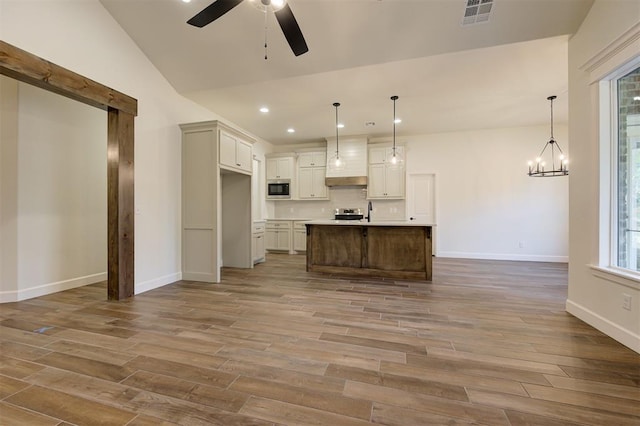 kitchen featuring pendant lighting, light wood-type flooring, and a kitchen island with sink