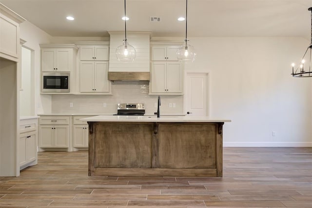 kitchen with decorative light fixtures, light hardwood / wood-style floors, and stainless steel appliances