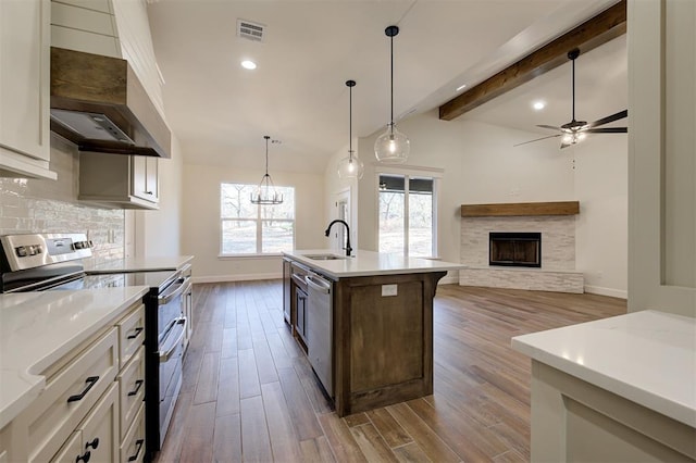 kitchen featuring a center island with sink, dark hardwood / wood-style flooring, white cabinetry, and stainless steel appliances