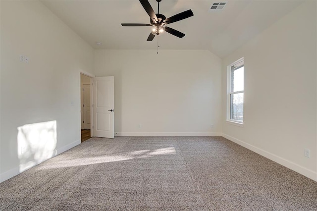 carpeted spare room featuring vaulted ceiling and ceiling fan