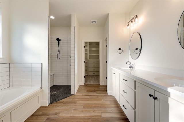 bathroom featuring independent shower and bath, vanity, and wood-type flooring