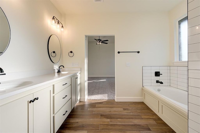 bathroom featuring vanity, hardwood / wood-style flooring, ceiling fan, and a bathing tub