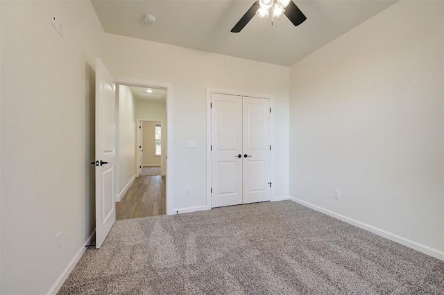 unfurnished bedroom with ceiling fan, light colored carpet, and a closet