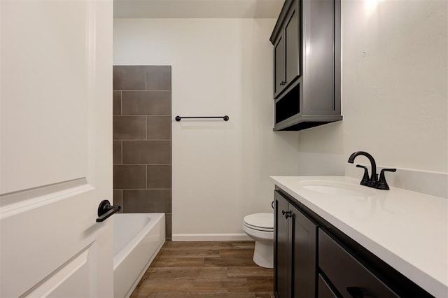 full bathroom with tiled shower / bath, toilet, vanity, and hardwood / wood-style flooring