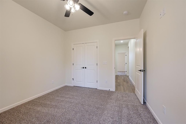 unfurnished bedroom with a closet, light colored carpet, and ceiling fan