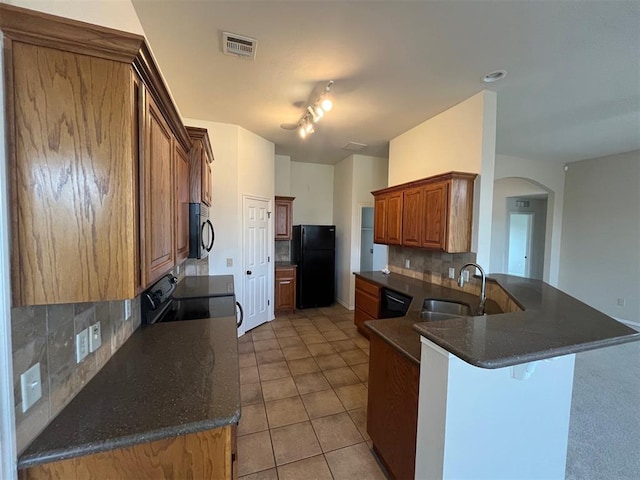 kitchen with kitchen peninsula, sink, tasteful backsplash, and black appliances