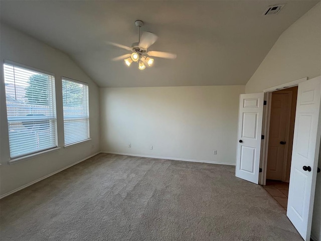 carpeted empty room featuring ceiling fan and vaulted ceiling