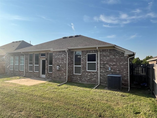 rear view of property with central air condition unit, a yard, and a patio