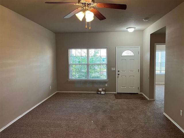 entryway with dark carpet and ceiling fan