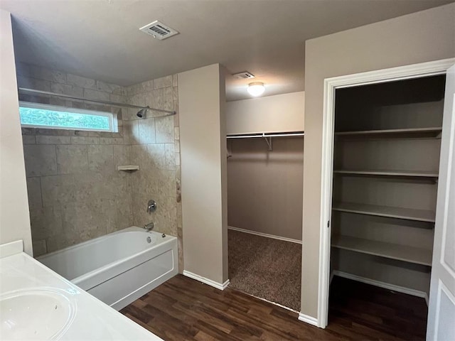 bathroom featuring vanity, wood-type flooring, and tiled shower / bath combo