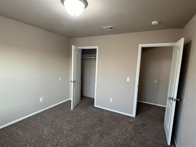 unfurnished bedroom featuring dark carpet and a closet