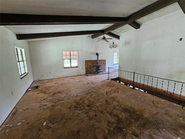 unfurnished living room featuring vaulted ceiling with beams, a wood stove, and ceiling fan