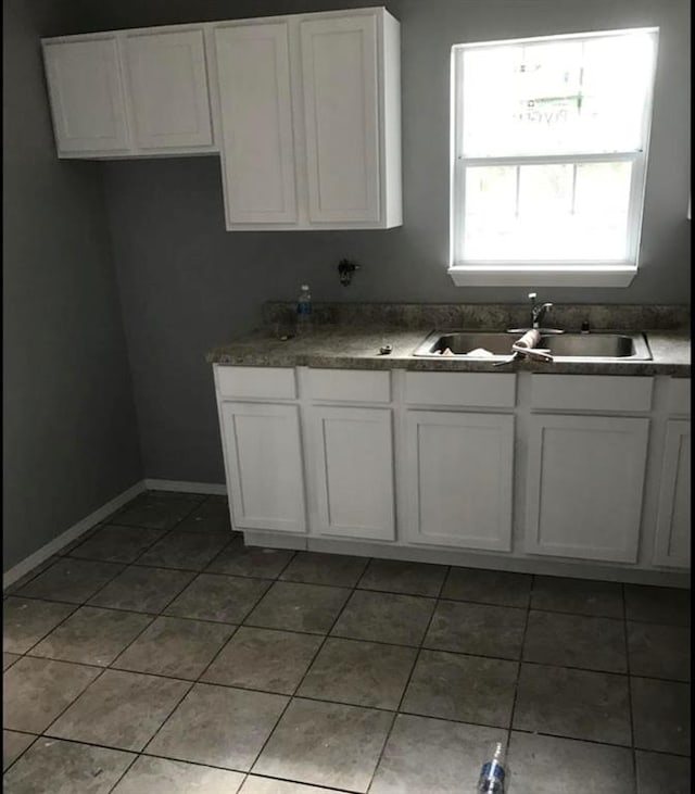 kitchen featuring sink, white cabinets, and tile patterned flooring