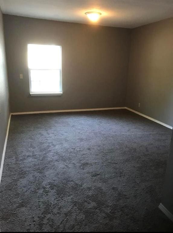 empty room featuring dark colored carpet