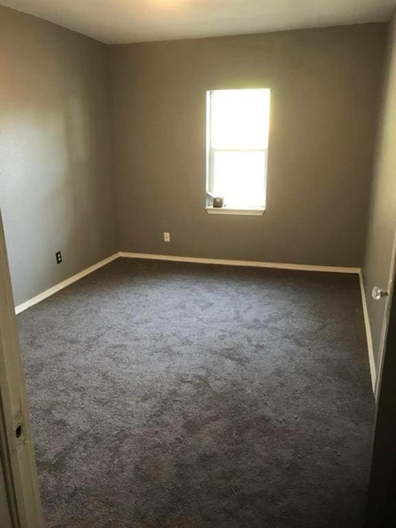 empty room with dark colored carpet