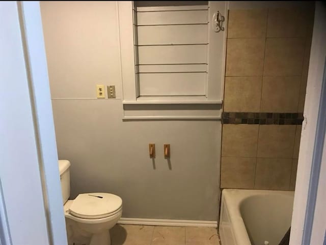 bathroom with tile patterned floors, a bathtub, and toilet