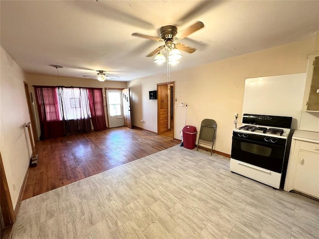 kitchen featuring ceiling fan, light hardwood / wood-style floors, and white gas range oven