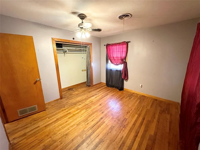 unfurnished bedroom with a closet, light hardwood / wood-style flooring, and ceiling fan