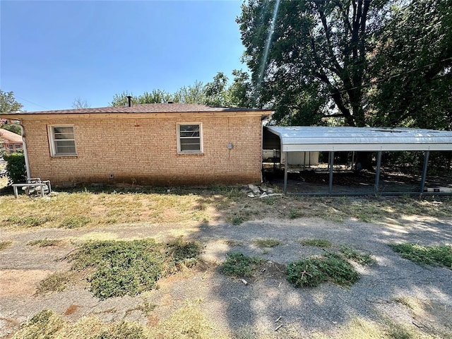 back of house featuring a carport