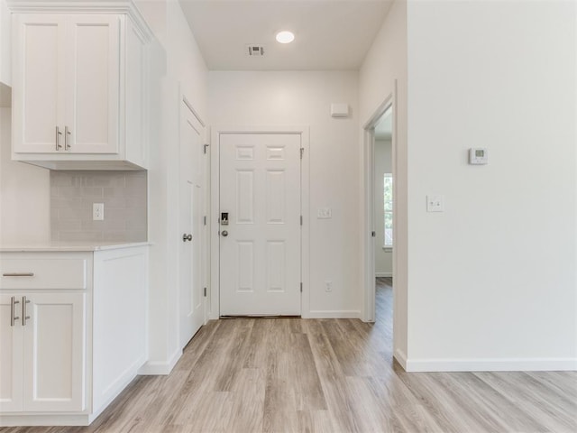 hallway with light hardwood / wood-style floors