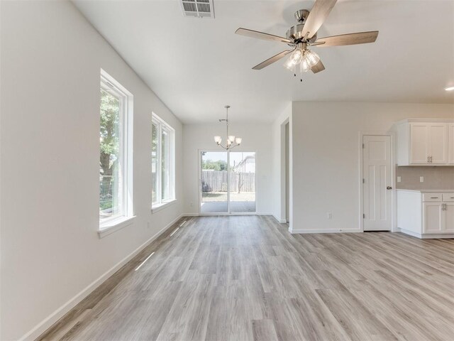 unfurnished living room featuring ceiling fan with notable chandelier and light hardwood / wood-style floors