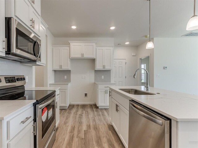 kitchen with white cabinets, decorative light fixtures, stainless steel appliances, and sink