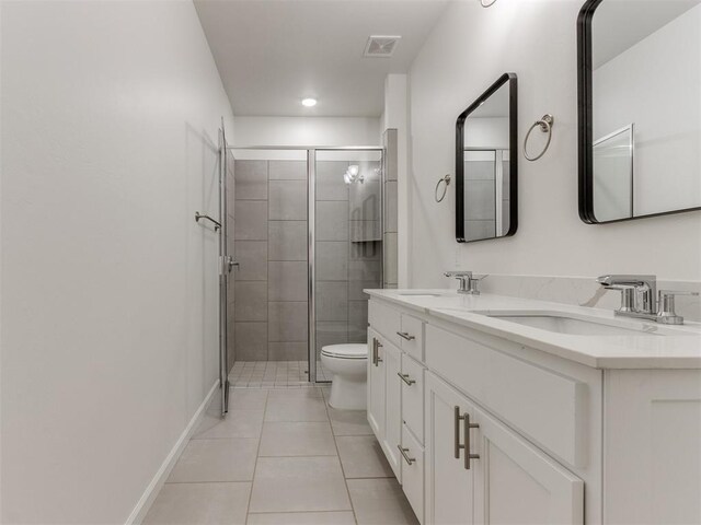 bathroom featuring tile patterned flooring, vanity, toilet, and an enclosed shower