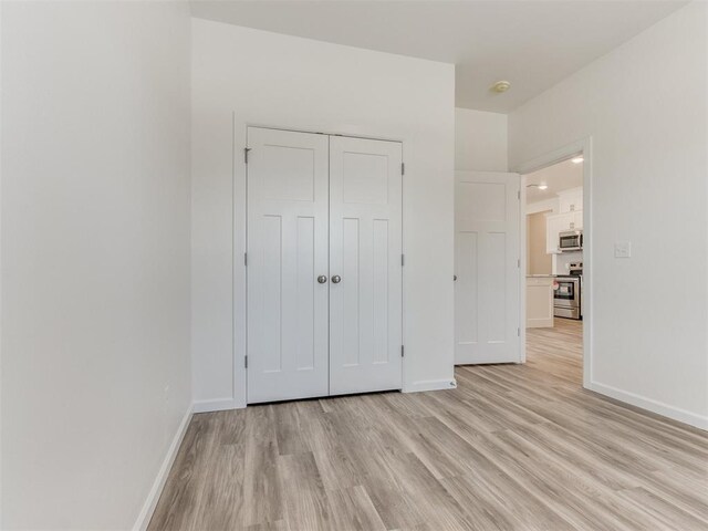 unfurnished bedroom with a closet and light hardwood / wood-style flooring