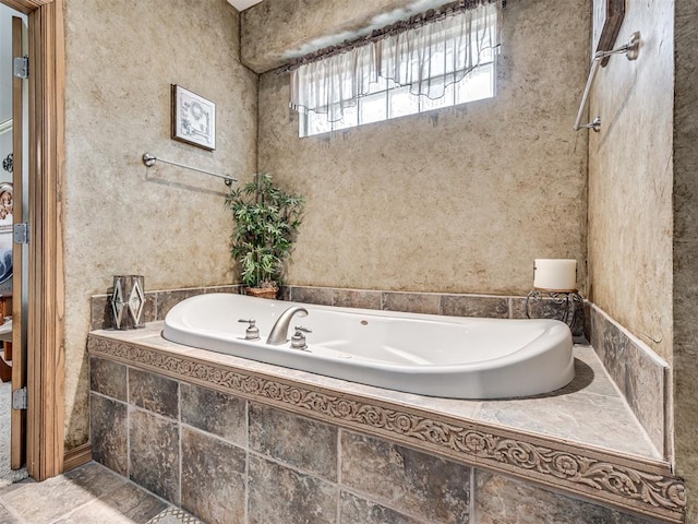 bathroom with a relaxing tiled tub