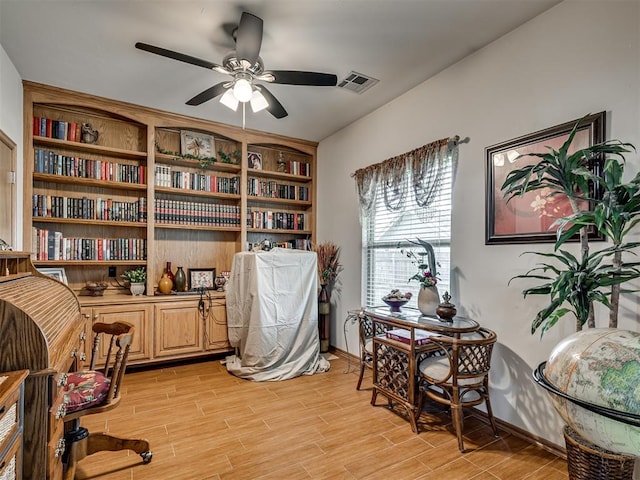 office with light hardwood / wood-style flooring and ceiling fan