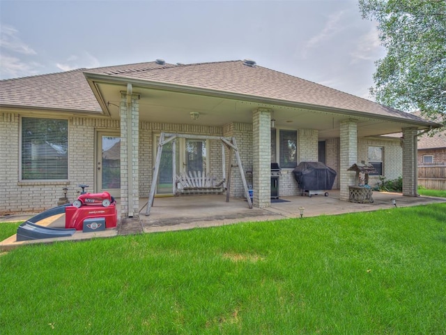 rear view of property featuring a yard and a patio