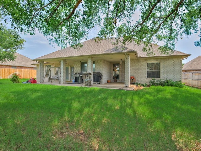 back of property with a lawn and a patio