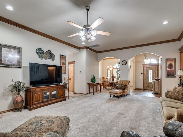 carpeted living room featuring ceiling fan with notable chandelier and ornamental molding