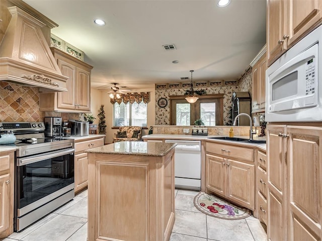 kitchen featuring sink, white appliances, premium range hood, a kitchen island, and kitchen peninsula