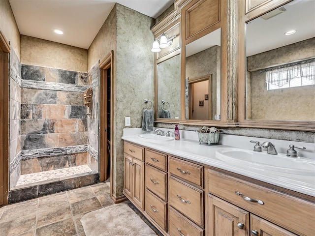 bathroom with vanity and a tile shower