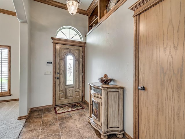 foyer entrance featuring ornamental molding and carpet floors