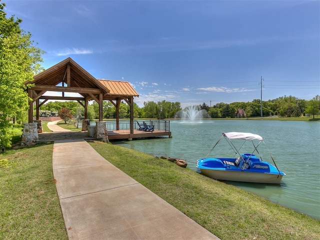 view of dock with a gazebo, a yard, and a water view