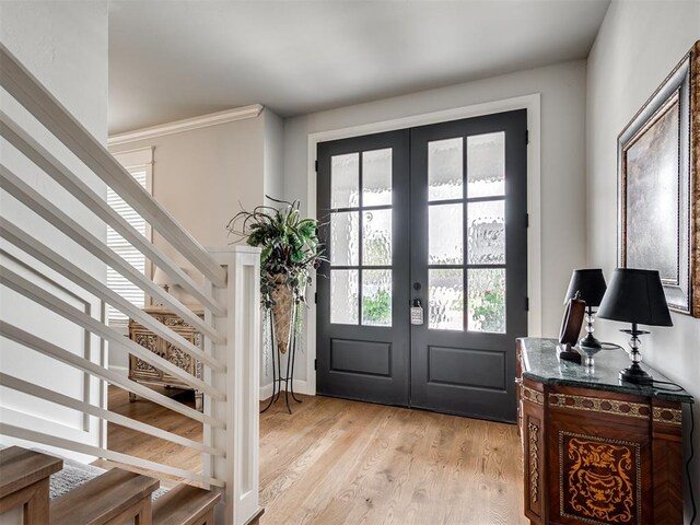 foyer entrance with french doors and light hardwood / wood-style flooring