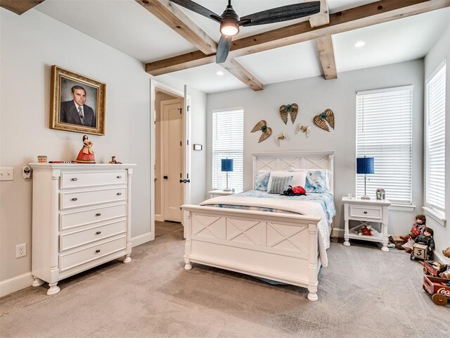 carpeted bedroom with beamed ceiling, multiple windows, and ceiling fan