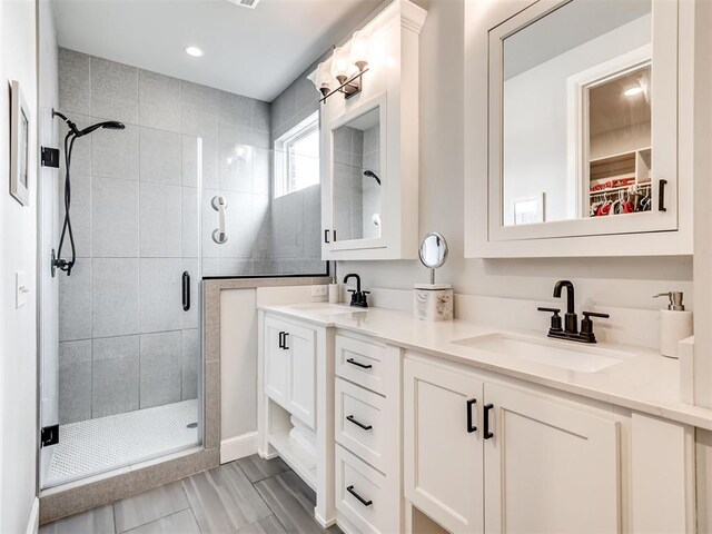 bathroom with vanity and a shower with door