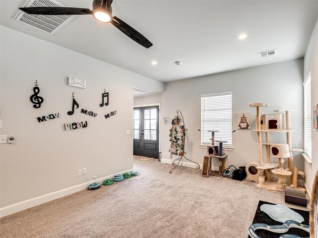 exercise area featuring carpet flooring, ceiling fan, and french doors