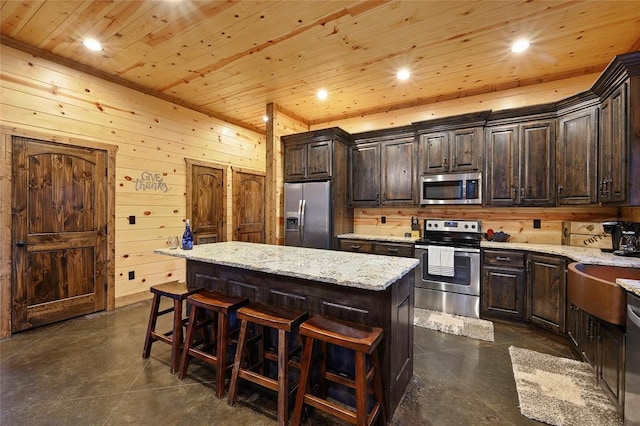 178 Black Jack Trl, Broken Bow, OK 74728 - kitchen with appliances with stainless steel finishes, wood ceiling, a kitchen island, a breakfast bar area, and dark brown cabinetry