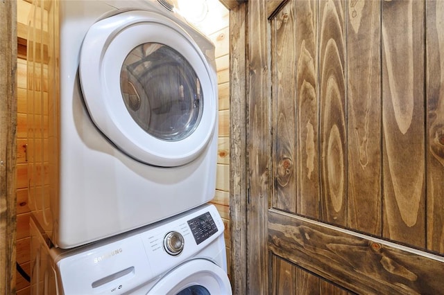 clothes washing area featuring stacked washer / dryer